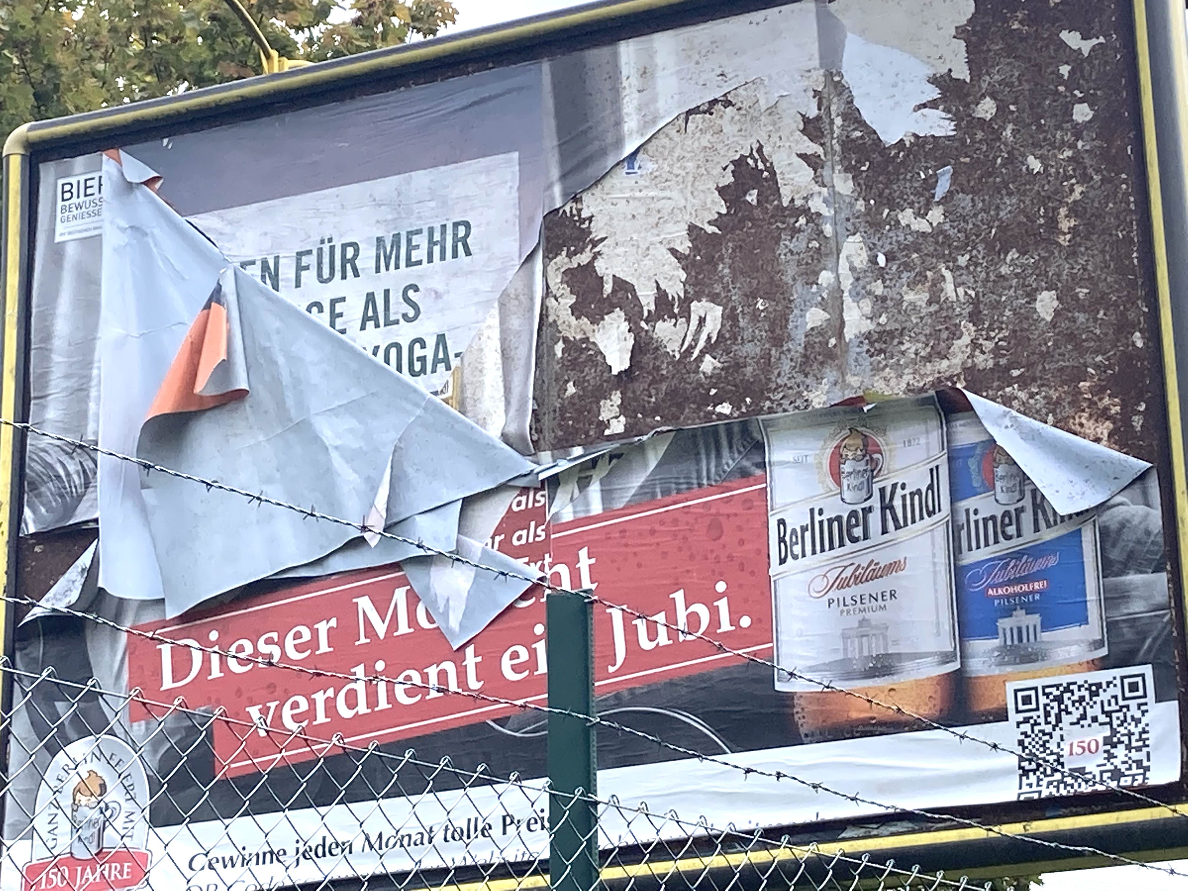 Peeling layers of old posters on a billboard sign